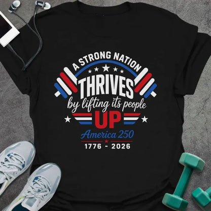 Black t-shirt printed with "A STRONG NATION THRIVES by lifting its people UP" in red and white, with barbells and stars in American flag style