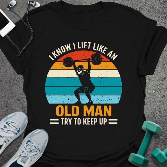 Black t-shirt printed with "I Know I Lift Like an Old Man Try to Keep Up" in orange, white, green, light blue, with a person lifting and rainbow sunset background
