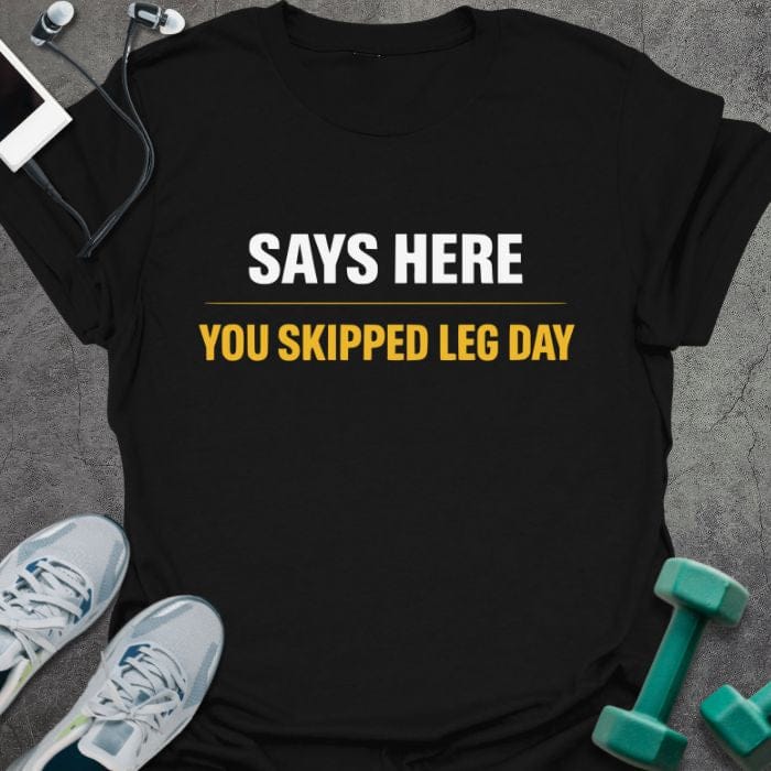 Black t-shirt printed with "Says Here You Skipped Leg Day" in white, orange