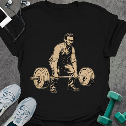 Black t-shirt with Abraham Lincoln doing deadlift graphic in tan and black