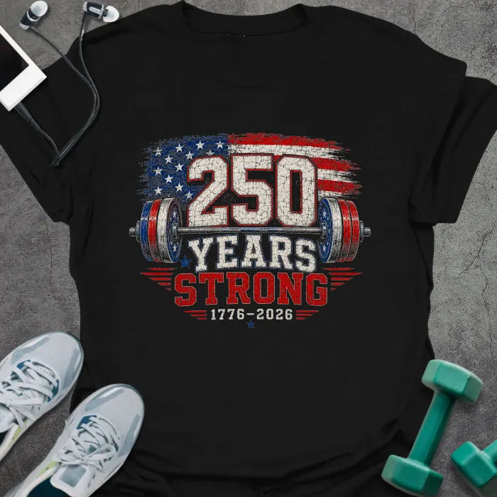 Black t-shirt printed with "250 Years Strong 1776-2026" in red, white, and blue, with an American flag pattern and barbell