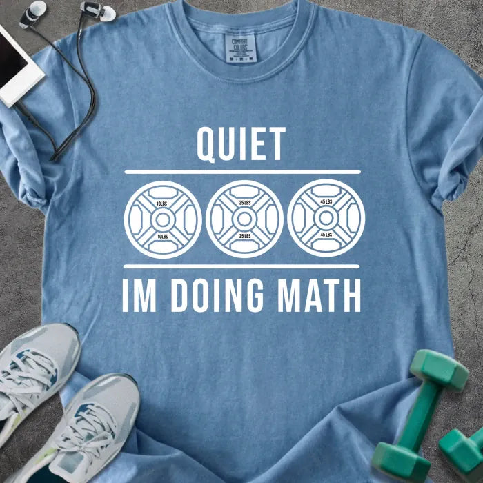 Blue jean t-shirt printed with "Quiet Im Doing Math" in white, with three weight plate graphics