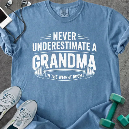 Blue jean t-shirt printed with "Never Underestimate a Grandma in the Weight Room" in white, with a barbell graphic