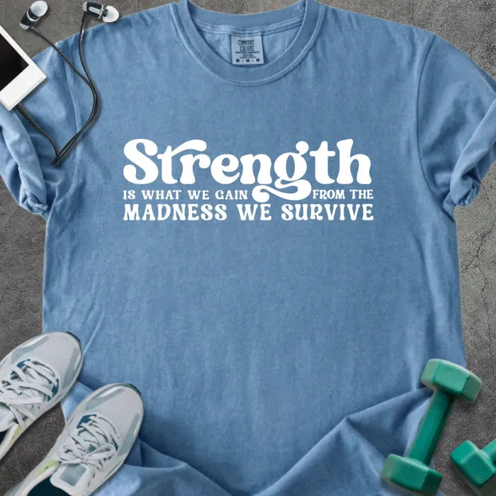 Blue jean t-shirt printed with "Strength is WHAT WE GAIN FROM THE MADNESS WE SURVIVE" in white