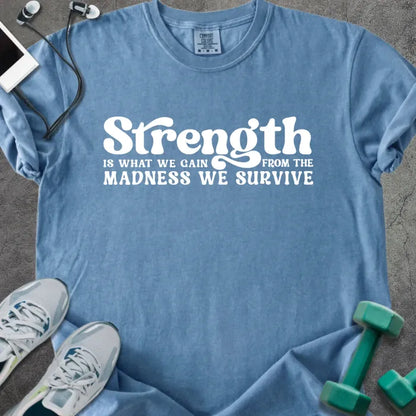 Blue jean t-shirt printed with "Strength is WHAT WE GAIN FROM THE MADNESS WE SURVIVE" in white