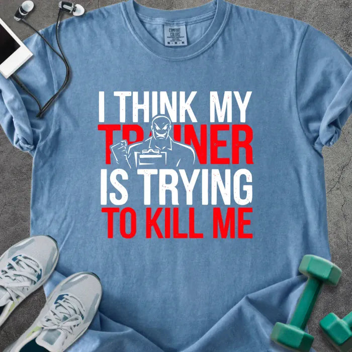 Blue jean t-shirt printed with "I Think my Trainer is Trying to Kill Me" in red and white, with a trainer figure