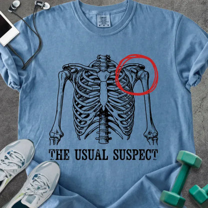 Blue jean t-shirt printed with "The Usual Suspect", with skeleton ribcage and red circled heart