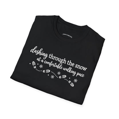 Folded black t-shirt printed with "dashing through the snow at a comfortable walking pace" in white, with a dotted trail of footprints and snowflakes