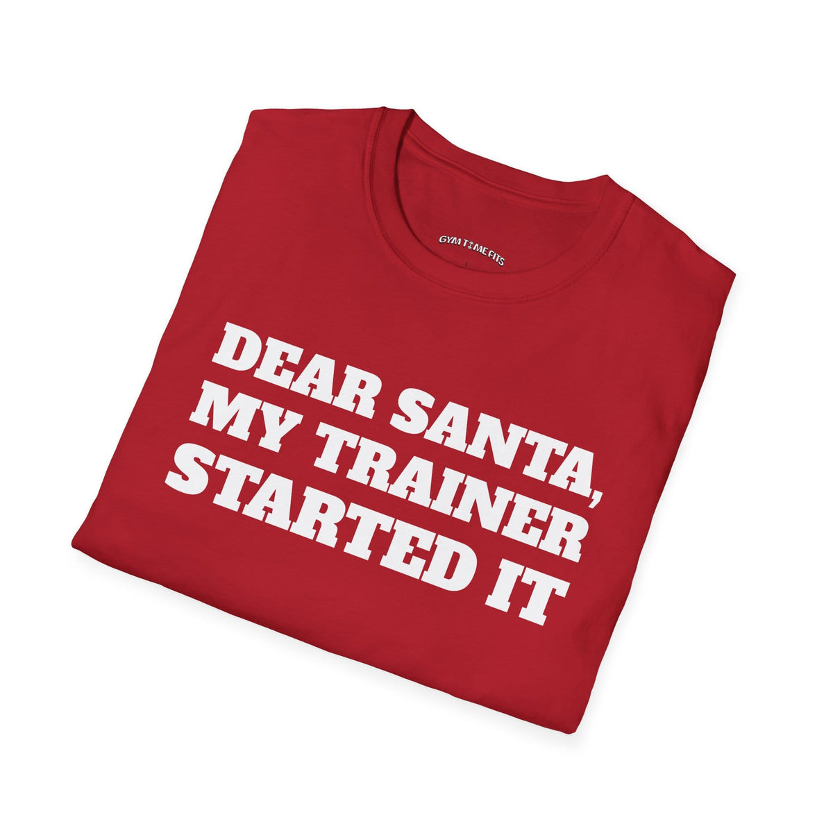 Folded cherry red t-shirt printed with "DEAR SANTA, MY TRAINER STARTED IT" in white