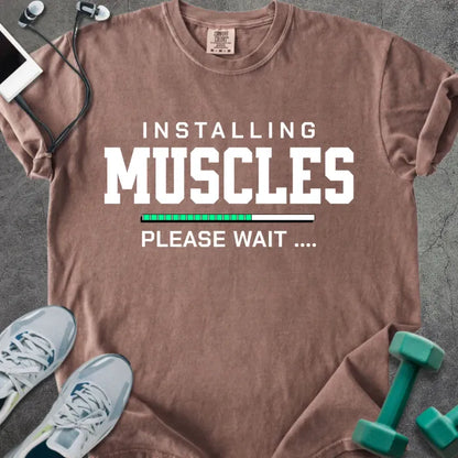 Espresso t-shirt printed with "Installing Muscles Please Wait ...." in white and multicolor, with a loading bar
