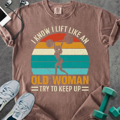 Espresso t-shirt printed with "I Know I Lift Like an Old Woman Try to Keep Up" in orange and multicolor, with a lifting silhouette and rainbow sunset