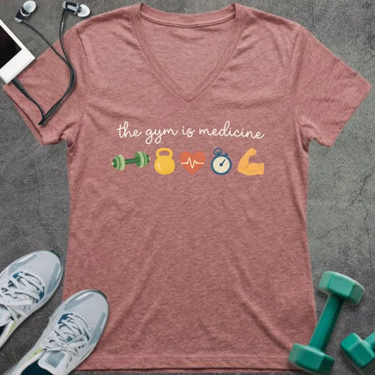 Heather mauve t-shirt printed with "the gym is medicine" in yellow and orange, with dumbbell, kettlebell, heartbeat, weight scale, clock, and bicep graphics
