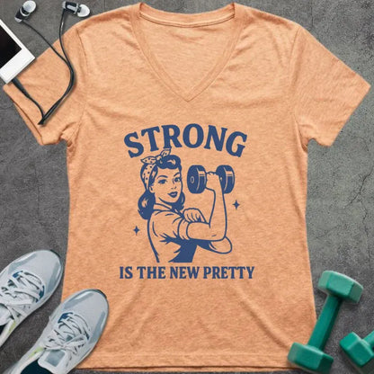 Heather peach t-shirt printed with "Strong is the New Pretty" in blue, with a woman flexing in Rosie the Riveter style