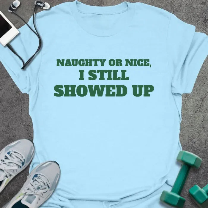 Light blue t-shirt printed with "NAUGHTY OR NICE, I STILL SHOWED UP" in green