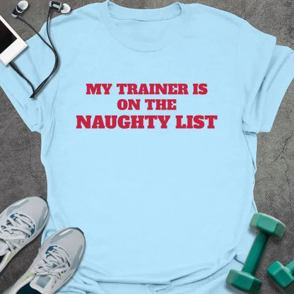Light blue t-shirt printed with "MY TRAINER IS ON THE NAUGHTY LIST" in red