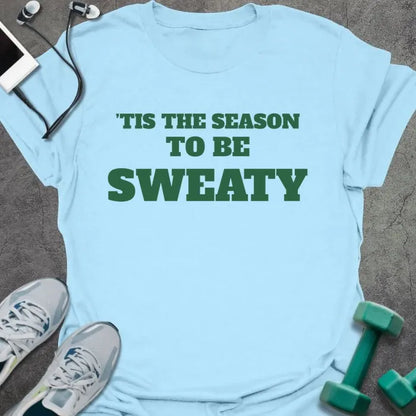 Light blue t-shirt printed with "'TIS THE SEASON TO BE SWEATY" in green