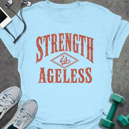 Light Blue t-shirt printed with "STRENGTH is AGELESS" in rust/terracotta weathered vintage lettering with diamond graphic