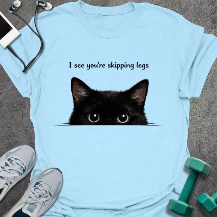 Light blue t-shirt printed with "I see you're skipping legs", with a black cat peeking over the bottom edge of the text