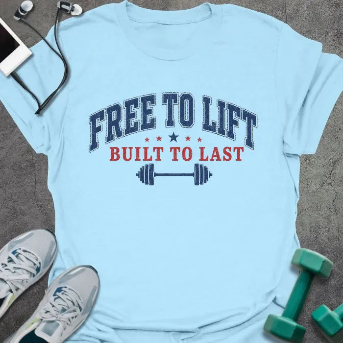 Light blue t-shirt printed with "Free to Lift Built to Last" in blue and red, with stars and a barbell