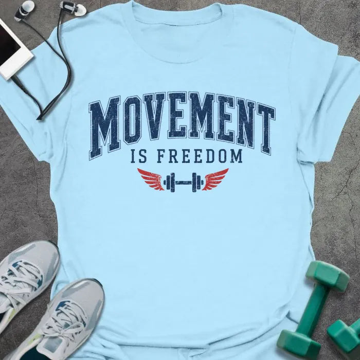 Light blue t-shirt printed with "Movement is Freedom" in blue and red, with red winged barbells