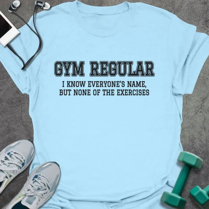 Light blue t-shirt printed with "GYM REGULAR, I KNOW EVERYONE'S NAME, BUT NONE OF THE EXERCISES" in charcoal
