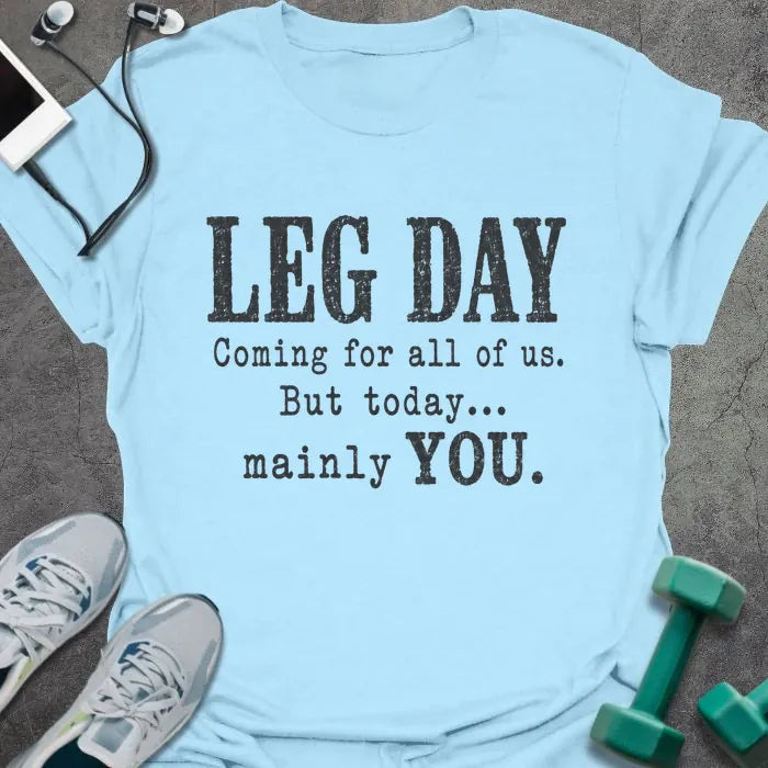 Light blue T-shirt printed with "LEG DAY Coming for all of us. But today... mainly YOU." in brown