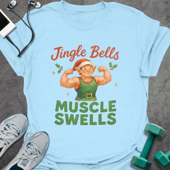 Light blue t-shirt printed with "Jingle Bells MUSCLE SWELLS" in red and green, with an illustration of a leprechaun flexing