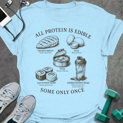 Light Blue t-shirt printed with "ALL PROTEIN IS EDIBLE" in black text with sepia-tone engraving style illustrations and 'SOME ONLY ONCE' at bottom