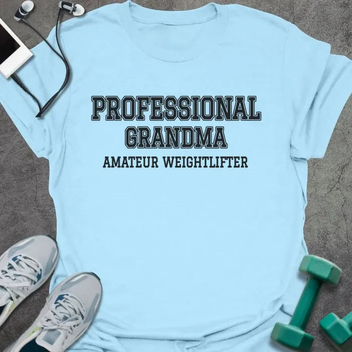 Light blue t-shirt printed with "PROFESSIONAL GRANDMA, AMATEUR WEIGHTLIFTER" in charcoal varsity letters