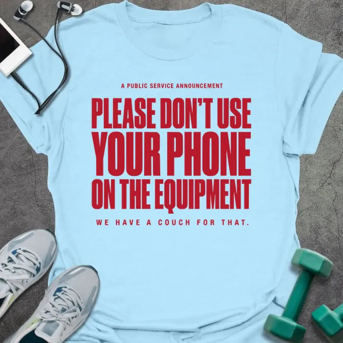 Light blue t-shirt printed with "A Public Service Announcement Please Don't Use Your Phone on the Equipment We Have a Couch for That." in red