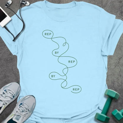 Light blue t-shirt printed with "REP BY REP BY REP" in green line art, with squiggle graphic