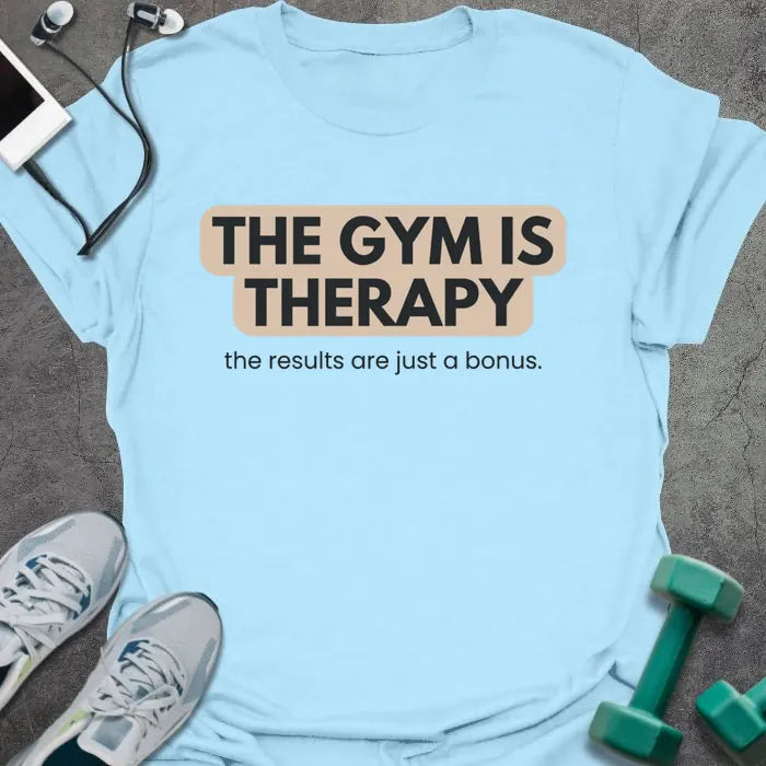 Light blue t-shirt printed with "THE GYM IS THERAPY the results are just a bonus." in black and gray
