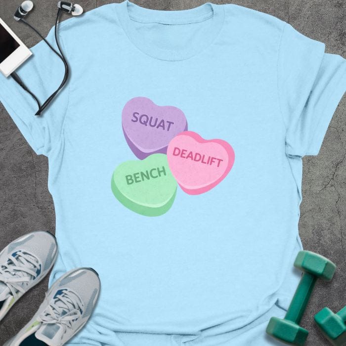 Light blue t-shirt printed with "Squat Bench Deadlift" in purple, green, pink, with three conversation candy hearts in purple, green, and pink