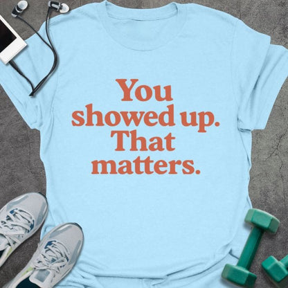 Light blue t-shirt printed with "You showed up. That matters." in red