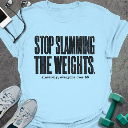 Light blue T-shirt printed with "STOP SLAMMING THE WEIGHTS. sincerely, everyone over 50" in black