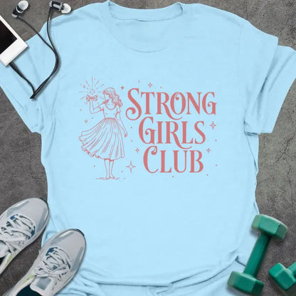 Light blue t-shirt printed with "Strong Girls Club" in pink, with a girl illustration and sparkles