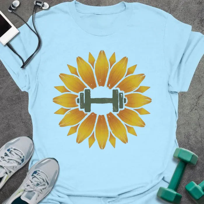 Light blue t-shirt with an illustration of a sunflower surrounding a dumbbell in yellow and green