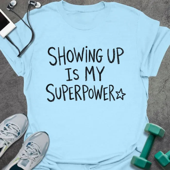 Light Blue t-shirt printed with "SHOWING UP IS MY SUPERPOWER" in black handwritten lettering, with a star outline