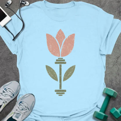 Light blue t-shirt with an illustration of tulip flowers surrounding a barbell in coral and green
