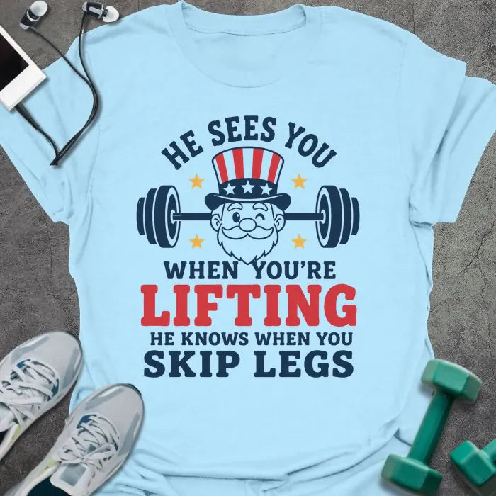 Light blue t-shirt with an American flag person lifting dumbbells graphic in white and red