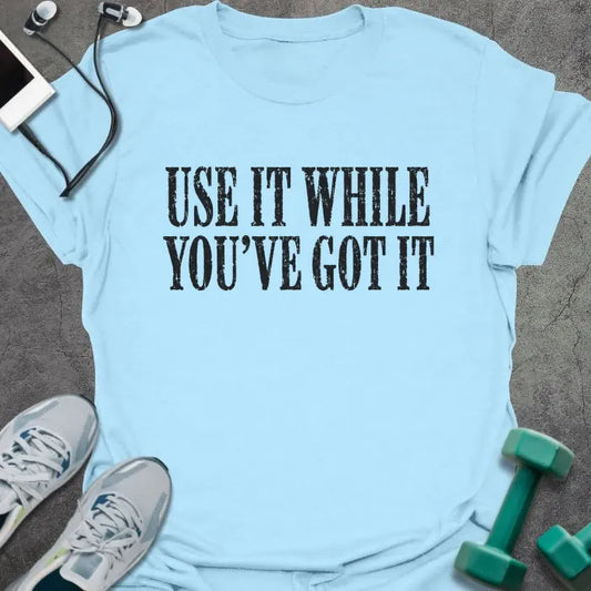 Light Blue t-shirt printed with "USE IT WHILE YOU'VE GOT IT" in dark navy distressed lettering
