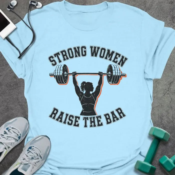 Light Blue t-shirt printed with "STRONG WOMEN RAISE THE BAR" in black lettering, with a silhouette of a woman weightlifter raising a barbell overhead