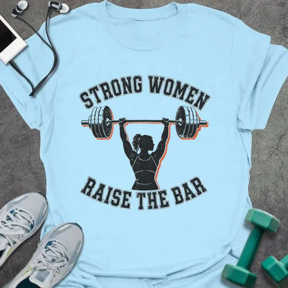 Light Blue t-shirt printed with "STRONG WOMEN RAISE THE BAR" in black lettering, with a silhouette of a woman weightlifter raising a barbell overhead