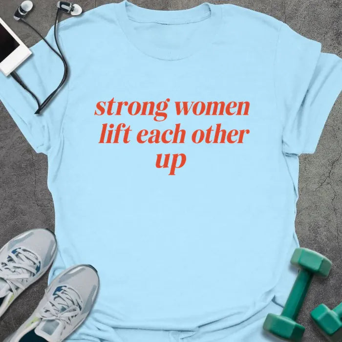 Light Blue t-shirt printed with "strong women lift each other up" in orange italic lettering