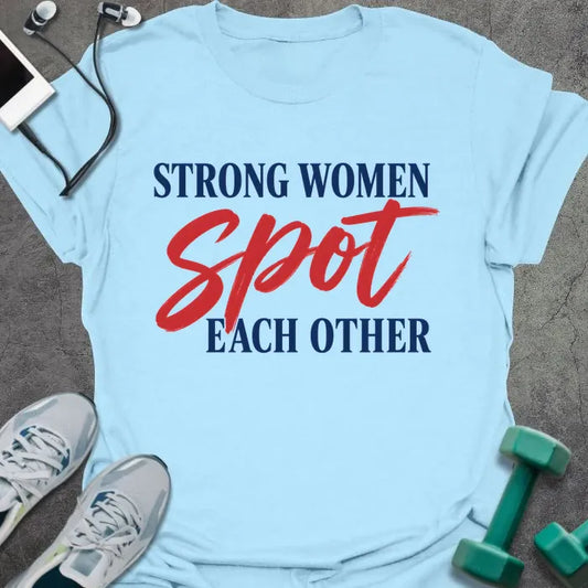 Light Blue t-shirt printed with "STRONG WOMEN spot EACH OTHER" in navy blue and red caps with red script accent