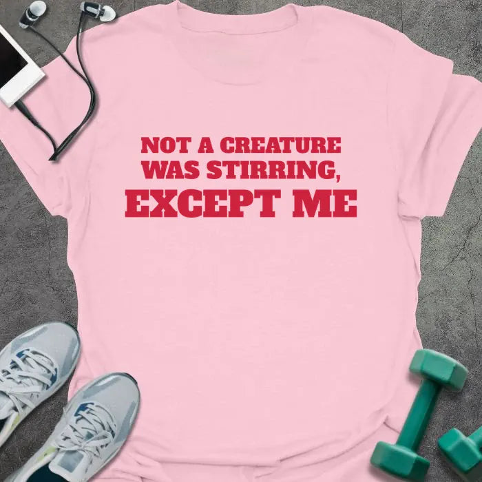 Light pink t-shirt printed with "NOT A CREATURE WAS STIRRING, EXCEPT ME" in red