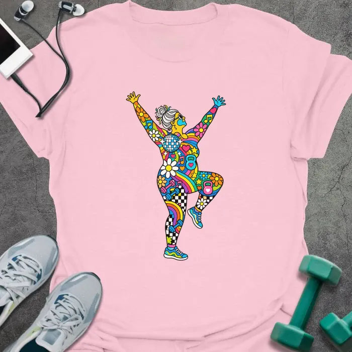 Light pink t-shirt printed with an older woman with a gray bun dancing with her arms up, her body filled with colorful flowers, rainbows, hearts, music notes and a disco ball