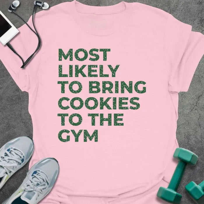 Light pink t-shirt printed with "MOST LIKELY TO BRING COOKIES TO THE GYM" in green