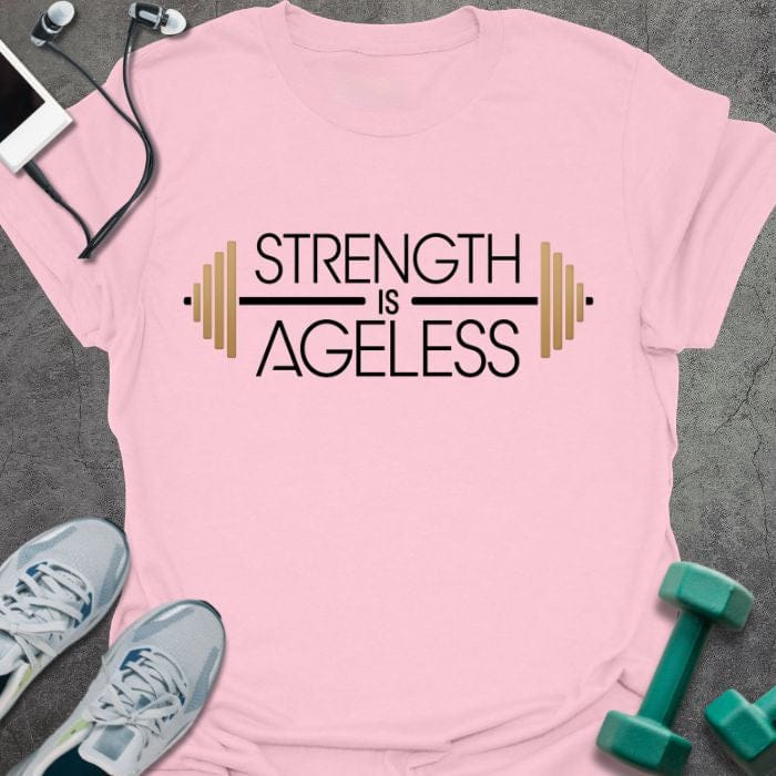 Light pink t-shirt printed with "Strength is Ageless" in yellow and blue, with barbell illustration