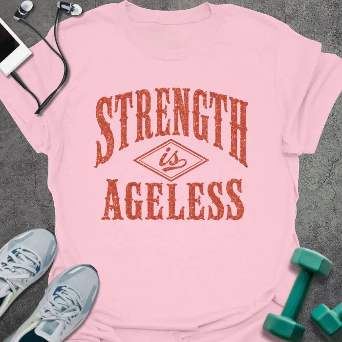 Light Pink t-shirt printed with "STRENGTH is AGELESS" in rust/terracotta weathered vintage lettering with diamond graphic